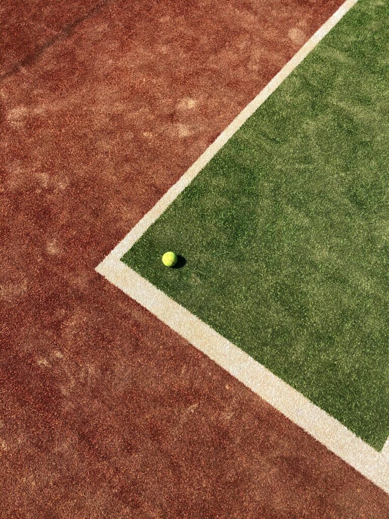 Close-up of a tennis ball on a mixed clay and grass court in Odesa, Ukraine.